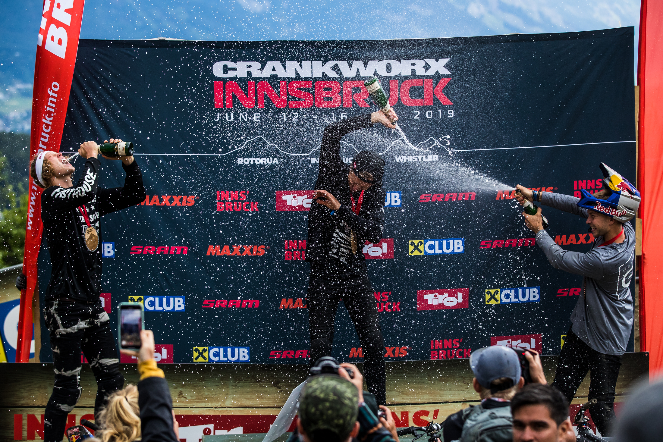 Champagne flies as Brett, Emil, and David celebrate. Crankworx Innsbruck 2019.